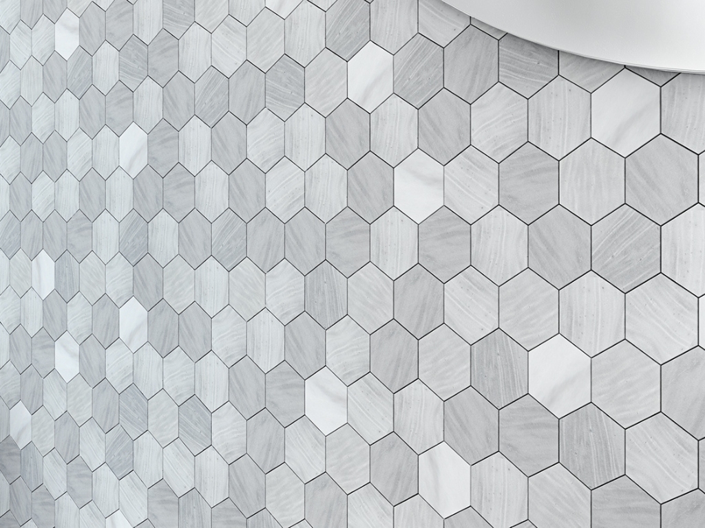 Close up photo with details of hexagon grey marble mosaics on a bathroom or shower wall surface