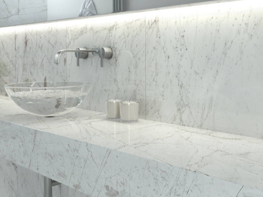 Close up photo of a luxury bath room with white marble tiles on marble counter sink and wall
