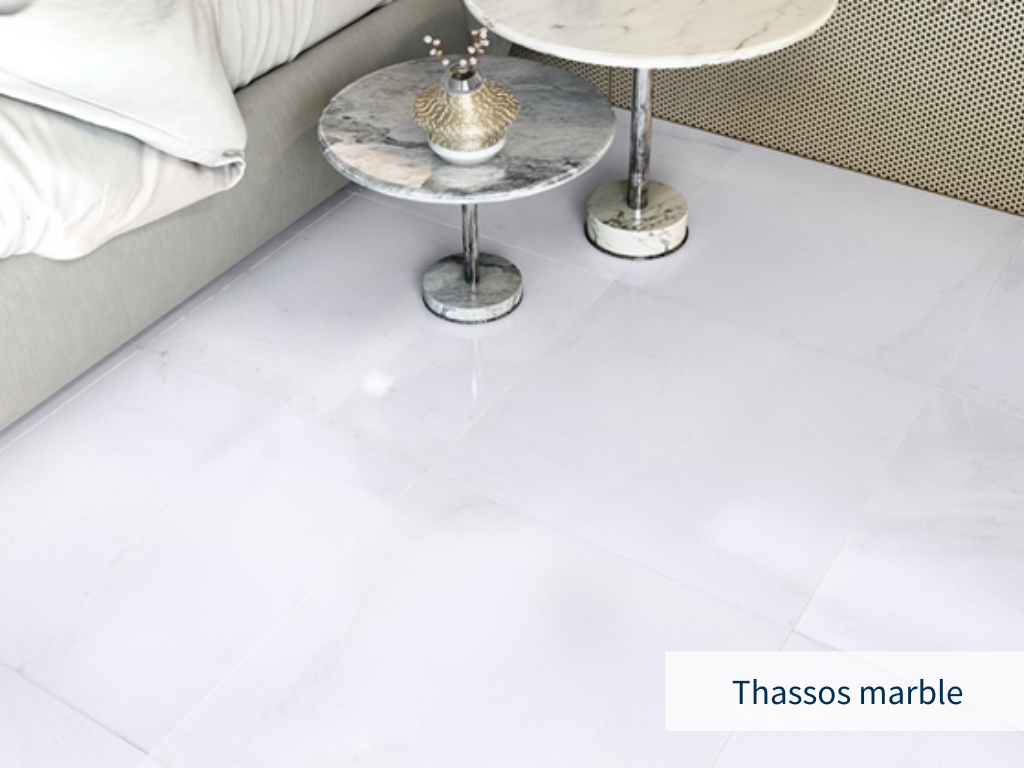 Minimal rendering of white flooring next to bed and stone tables. Types & Dimensions Of Thassos White Marble Tiles.