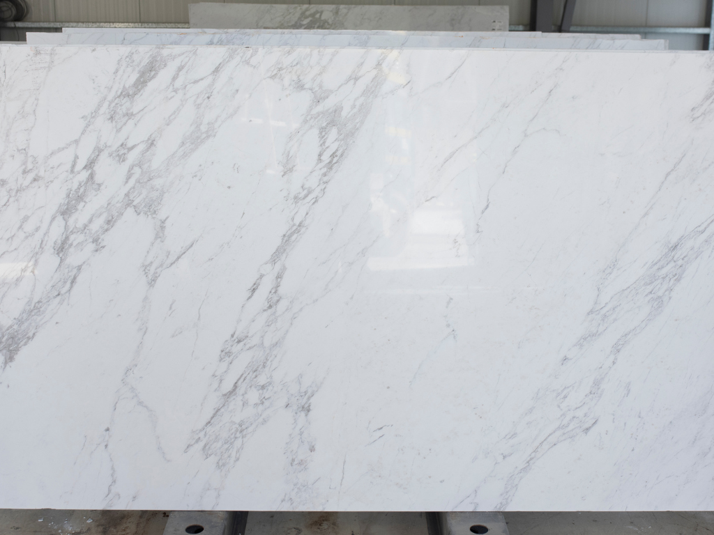 Photo of white stone marble slab with elegant grey veins in warehouse