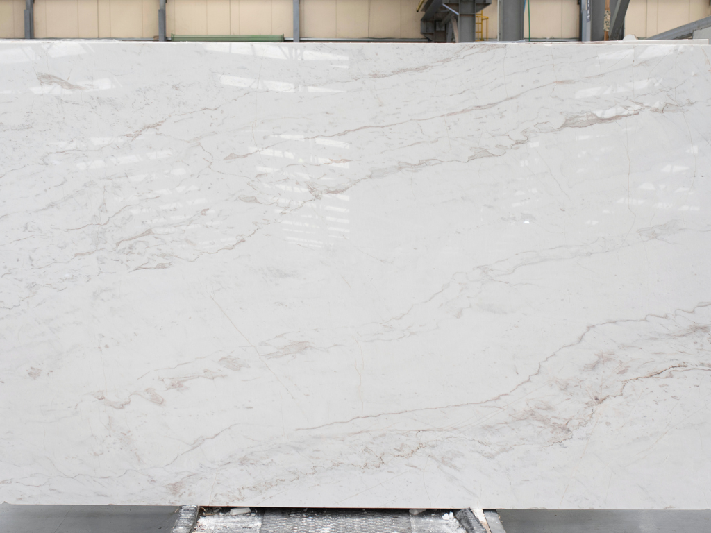 Pirgon alas marble slab by Stone Group International with a white background and brown veins and cloudy outlines