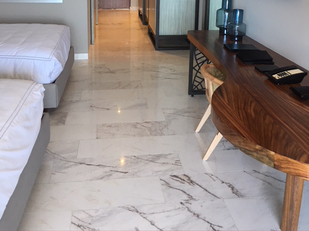 White marble tiles with distinct veins installed in a bedroom of a European hotel, by Stone Group International